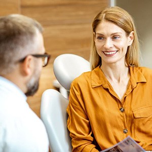 Dentist and patient conversing during dental implant consultation