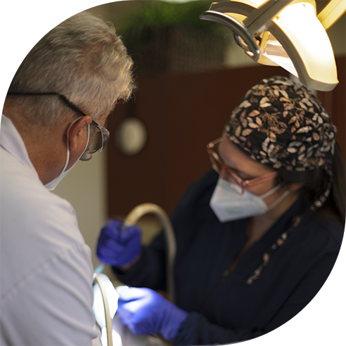 Friendly dental team member handing dental patient a clipboard