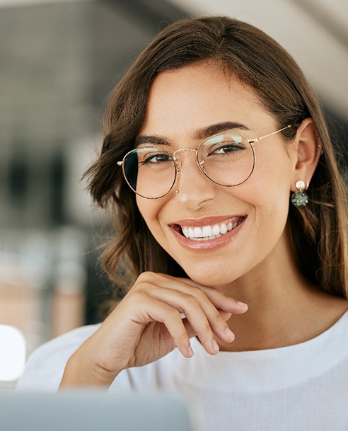 Confident, smiling woman sitting at computer