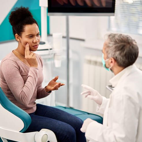 Patient explaining her symptoms to dentist