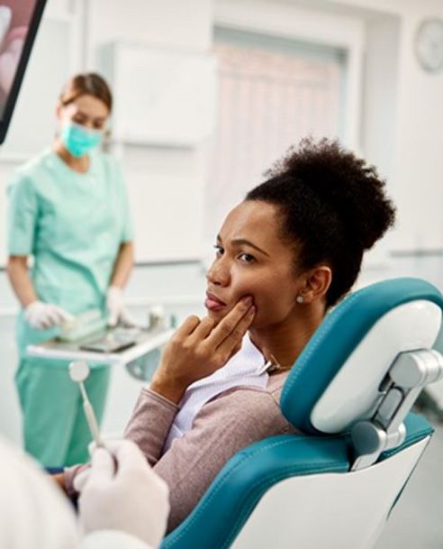 Woman with toothache, talking to dentist