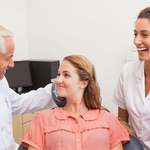 Dentist and patient engaged in friendly conversation