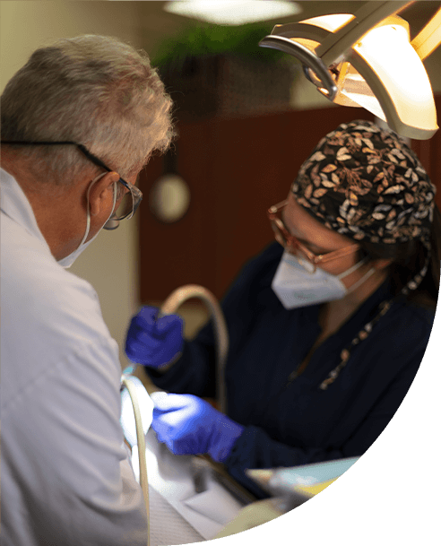 Dentist and team member treating dental patient