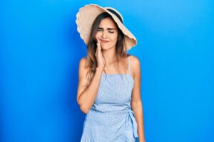 Woman in summer clothes, dealing with a toothache