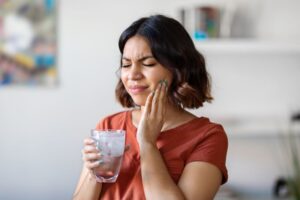 Grimacing woman experiencing dental sensitivity